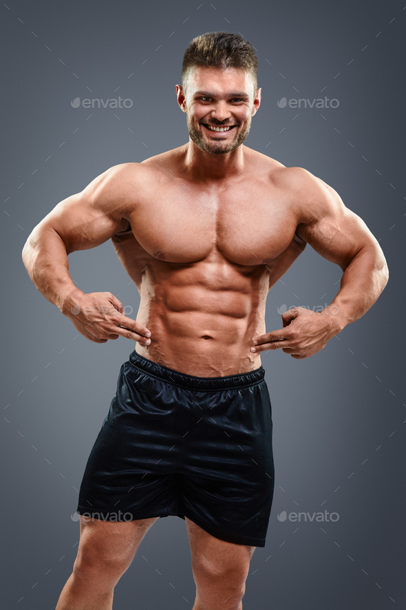 Bodybuilder man pointing at abs Stock Photo by kegfire PhotoDune